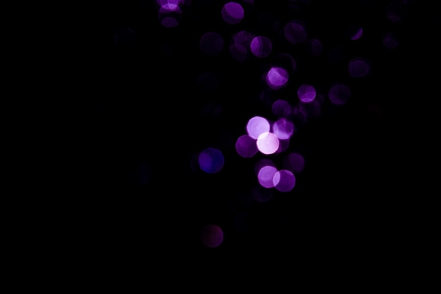 Abstract background purple bokeh with black background.