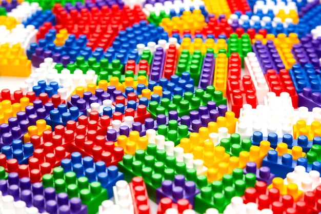 Abstract background texture of colored constructor blocks Background of colorful plastic part of constructor Pile of colored toy bricks