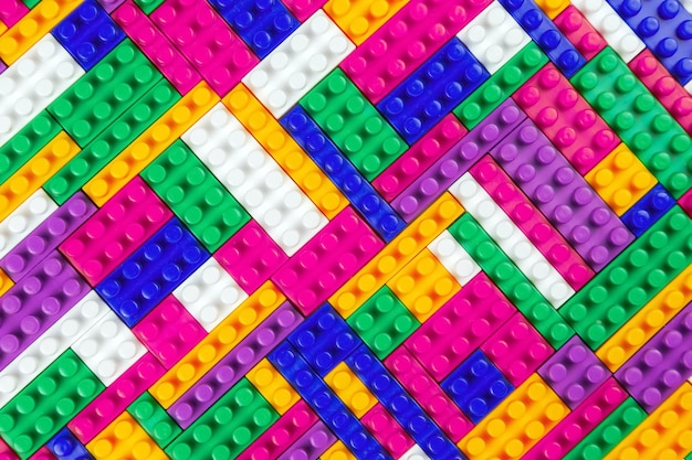 Abstract background texture of colored constructor blocks Background of colorful plastic part of constructor Pile of colored toy bricks