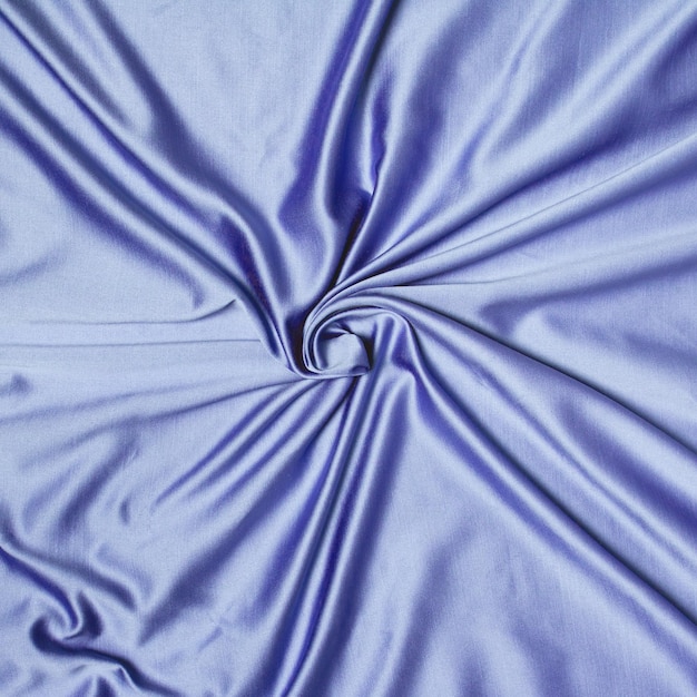 Abstract background texture of crumpled silk twisted in a spiral purple color