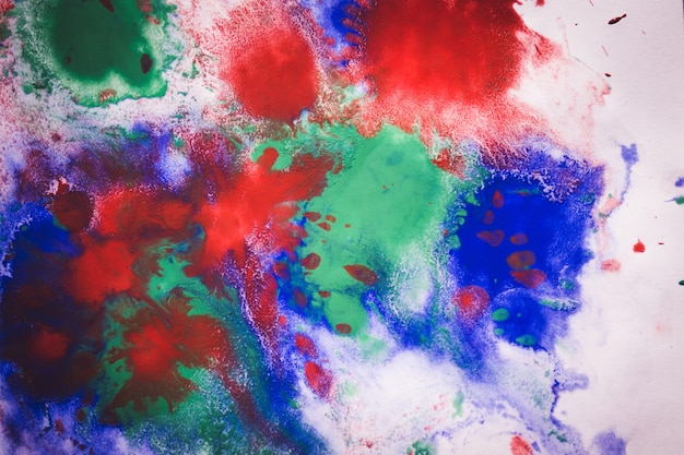 Abstract background with blots and spreads droplets of different colors on paper close-up, filter