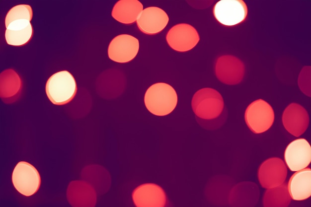 Abstract background with blurred red and white lights on a dark purple background