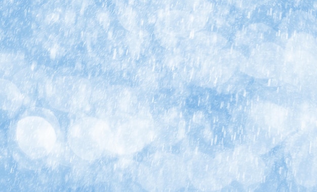 Abstract background with bokeh lights and snowfall. Image in light blue tone