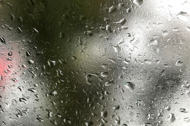 Abstract background with raindrops on frozen window and blurred day cloudy sky