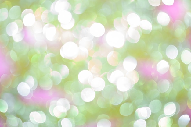 abstract background with shiny blurred green white pink colored spring lights in horizontal format