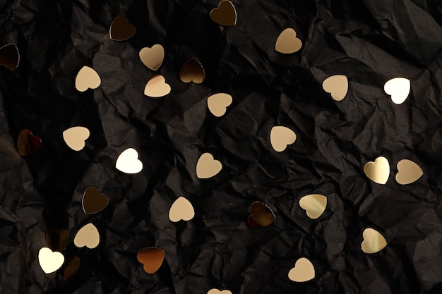 Photo abstract black background with golden hearts.valentines day concept.