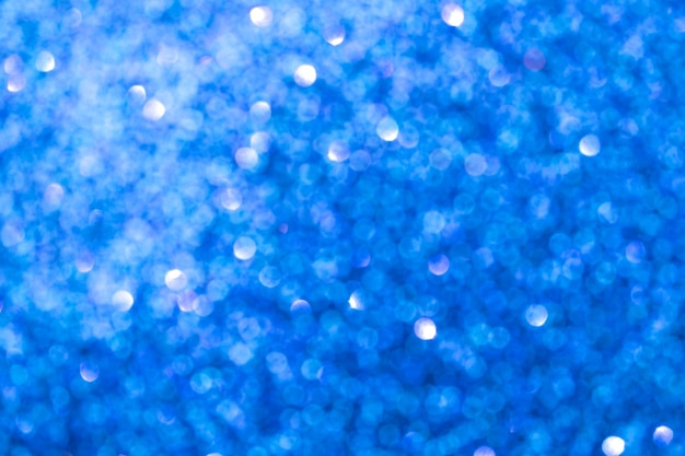 Abstract blue blurred bokeh background. Glitter shining lights. Festive and celebration backdrop for holiday, christmas and new year design, stock photo