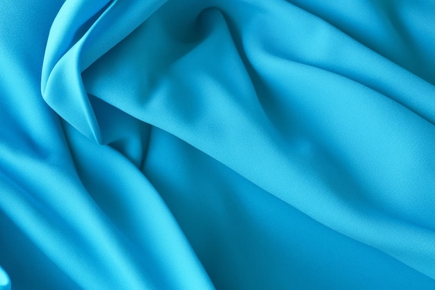 Abstract blue fabric texture with soft folds and wrinkles