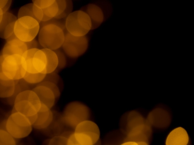 Abstract blur image of golden or yellow light of beautiful bokeh on black background with copy space Blurred festive night party and celebration bokeh background