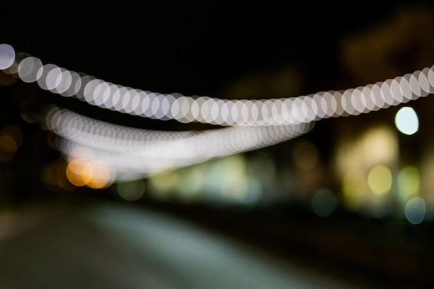 Photo abstract blurred background with bokeh colorful circles. city lifestyle backdrop made with street lamps and garland lights