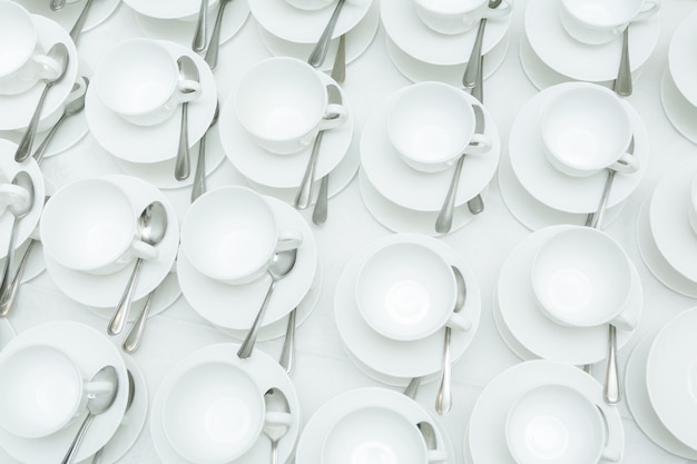 Abstract blurred of many white rows of coffee or tea cups for background.