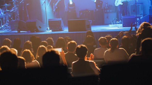 Abstract blurred - young man sitting on a rock concert in front of the stage