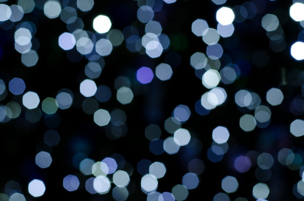 Abstract bokeh of festoon lights on dark background.