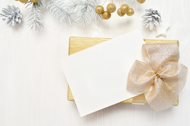 Abstract christmas background, white sheet of paper lying among small decorations on white wooden desk