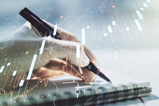 Abstract creative financial graph with world map and with woman hand writing in diary on background financial and trading concept Multiexposure