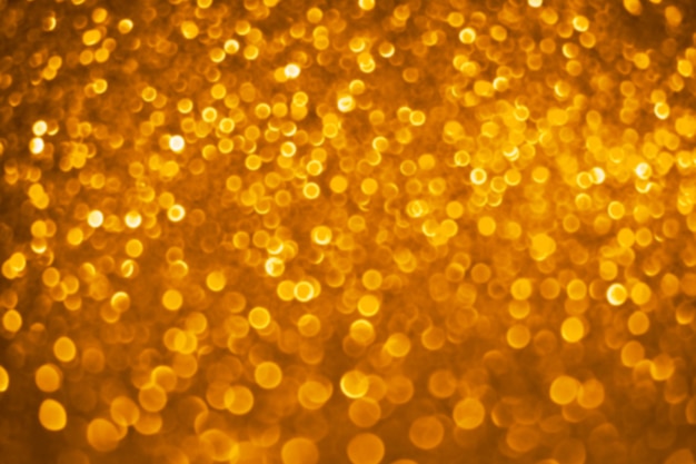 Abstract defocused golden bokeh background. Christmas bokeh lights. Festive glittering blurred texture