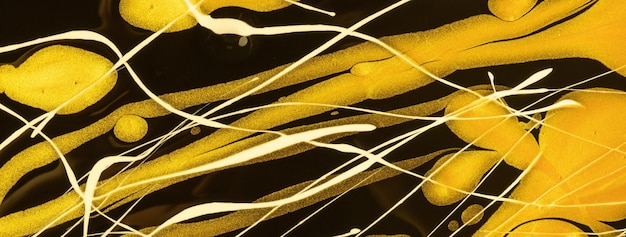 Abstract fluid art background black and golden colors Liquid marble Acrylic painting on canvas with yellow lines