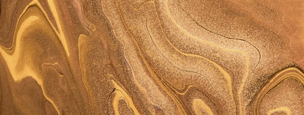 Abstract fluid art background golden and bronze colors Liquid marble Acrylic painting with brown lines and gradient