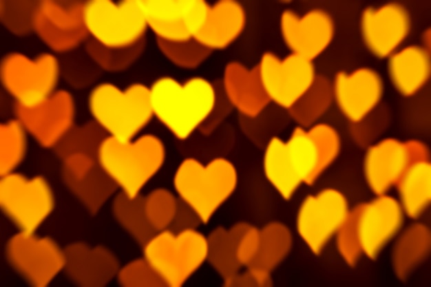 Photo abstract golden background with heart shaped bokeh