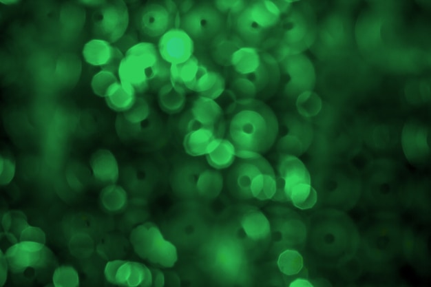 Abstract green backlight reflector and glitter bokeh lights background. Image is blurred ..