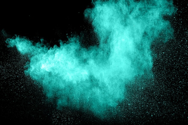 Abstract green dust explosion on black background.