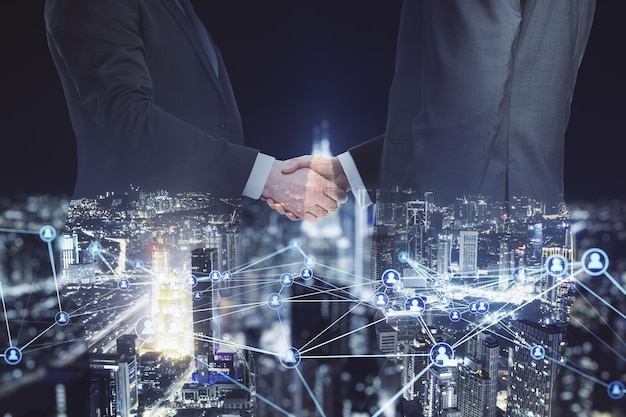 Abstract image of businesspeople shaking hands on blurry glowing polygonal network