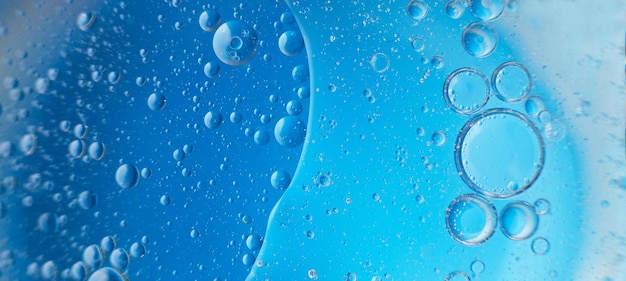 Abstract light blue background with oil circles bubbles of water close up banner