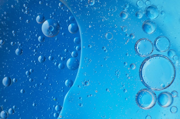 Abstract light blue background with oil circles bubbles of water close up oil bubbles