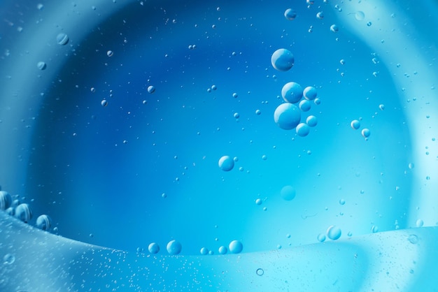 Abstract light blue background with oil circles bubbles of water close up