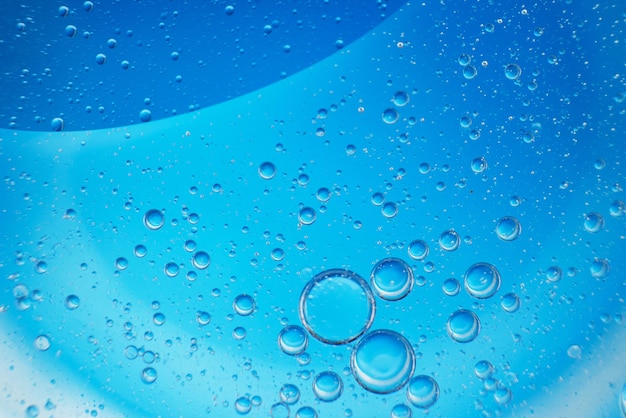 Abstract light blue background with oil circles bubbles of water close up