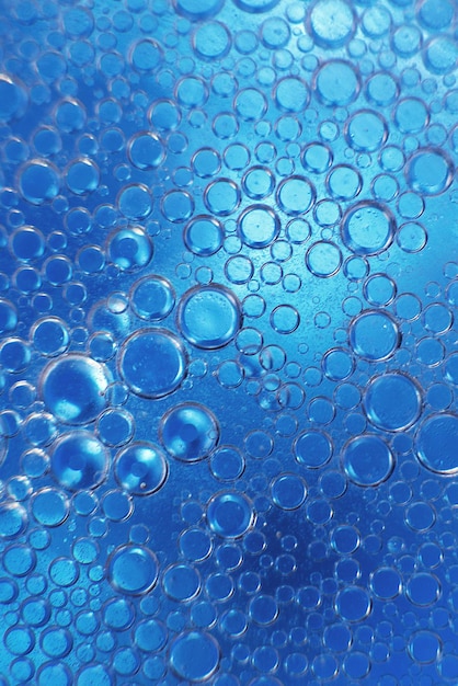 Abstract light blue background with oil circles bubbles of water close up