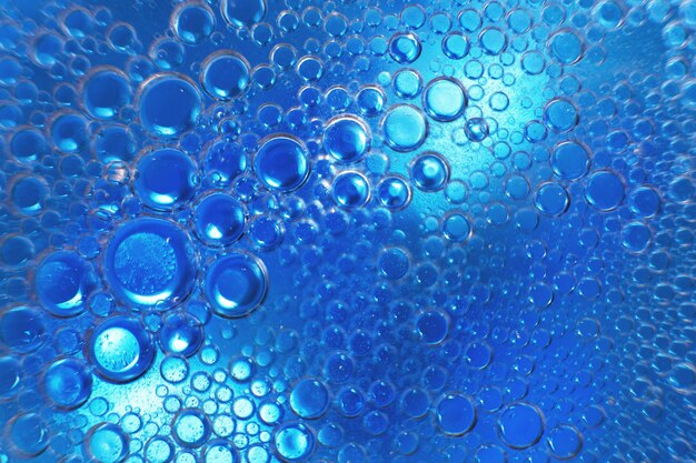 Abstract light blue background with oil circles  bubbles of water close up