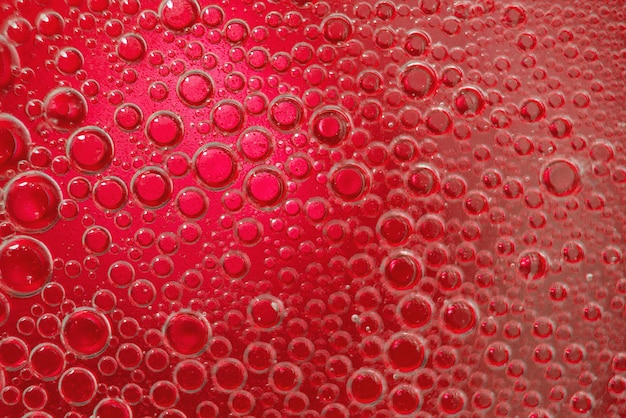 Abstract light red background with oil circles   bubbles of water close up