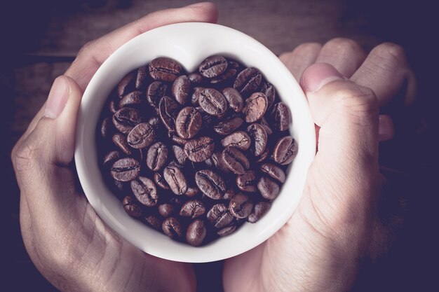 Abstract man hand holding cup of coffee love coffee love valentine background soft light vintage color tone