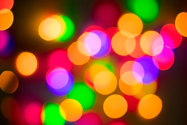 Abstract multi-colored bokeh on a black background. Defocused abstract lights christmas ba