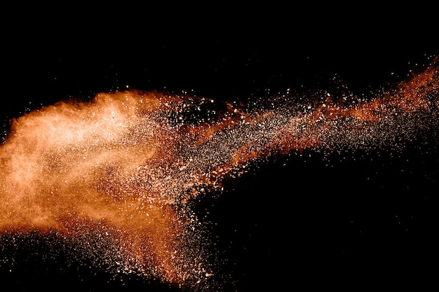 abstract orange powder explosion on black background. 