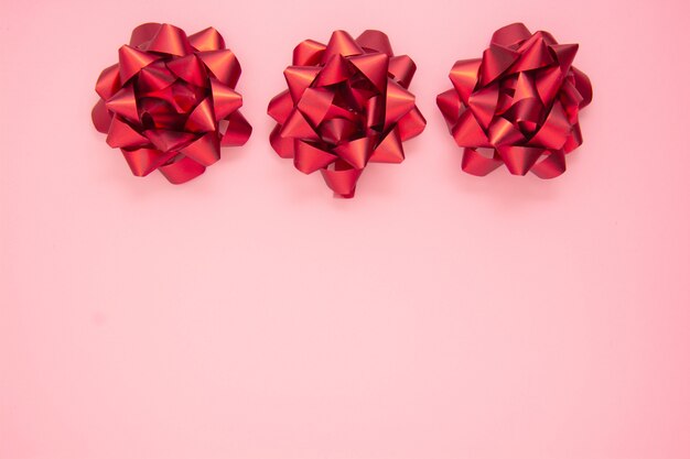 Abstract pink background with red gift ribbon bows. Valentine's Day, Love, birthday.