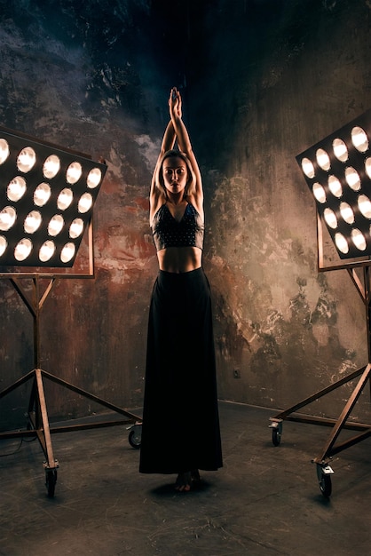 Abstract portrait of beautiful attractive blonde young woman dancer on the stage with lights in loft