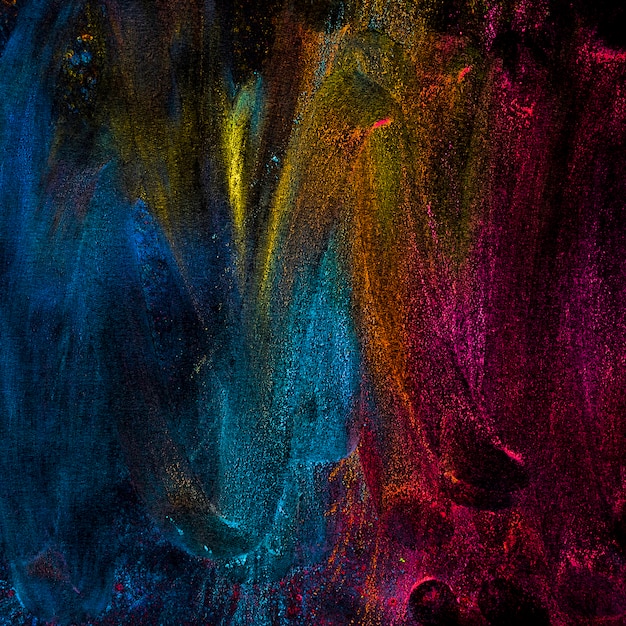 Abstract powder colors splatted over black backdrop