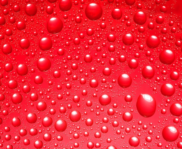 Abstract red background.  Liquid on glass. Colorful waterdrops