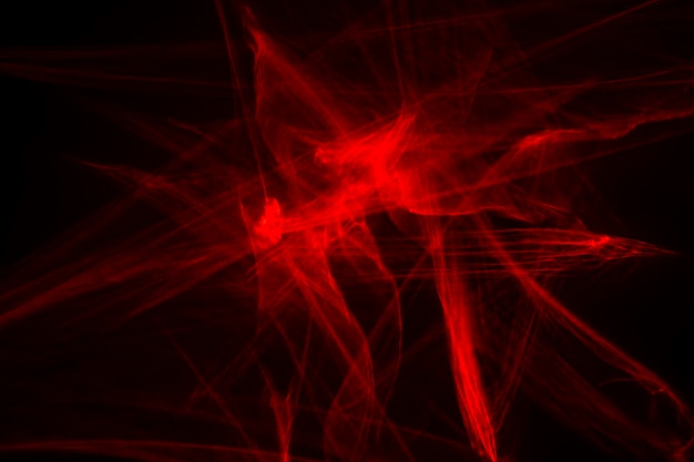 Abstract red lines drawn by light on a black background. Laser lines