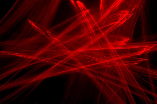 Abstract red lines drawn by light on a black background. Laser lines