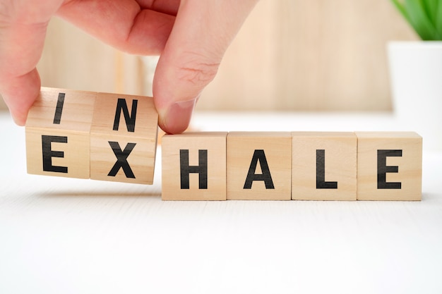 Abstract selection of inhale exhale phrases on wooden blocks.