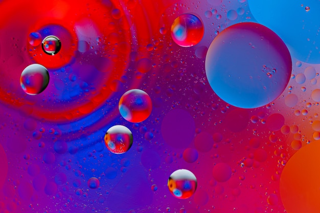 Abstract space background of oil drops on the water surface in neon color