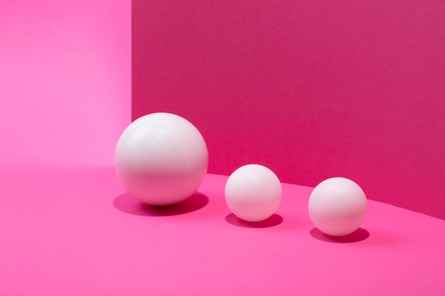 Abstract still life with white balls on a pink background