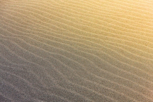 abstract wave line textures on Pacific beach illuminated by Sun and an empty quarter