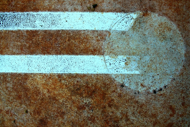 Abstract white lines lead to a whitish circle on a pockmarked orange rust background