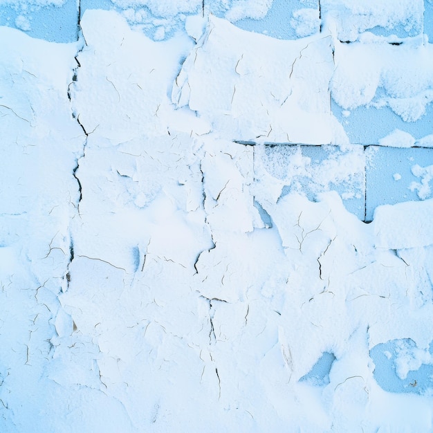 Photo abstract winter texture frozen brick wall with cracked paint