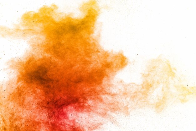 Abstract yellow orange powder explosion on white surface