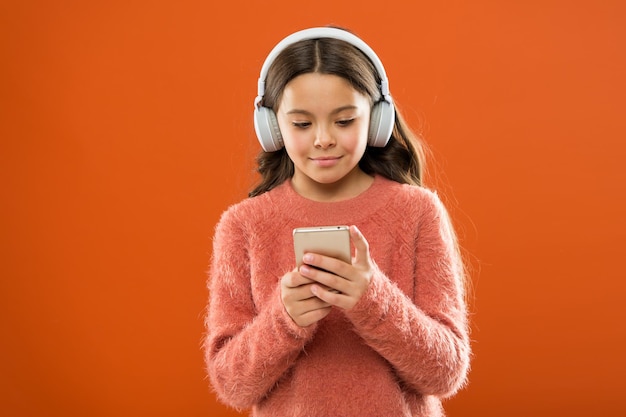 Access to millions of songs. Enjoy music concept. Best music apps that deserve a listen. Girl child listen music modern headphones and smartphone. Listen for free. Get music family subscription.